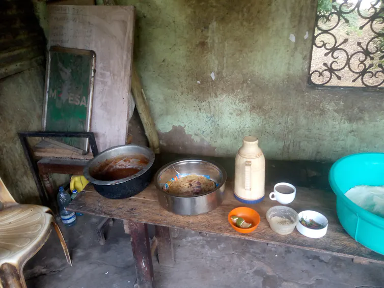A room with a bench holding various containers of food and drink.