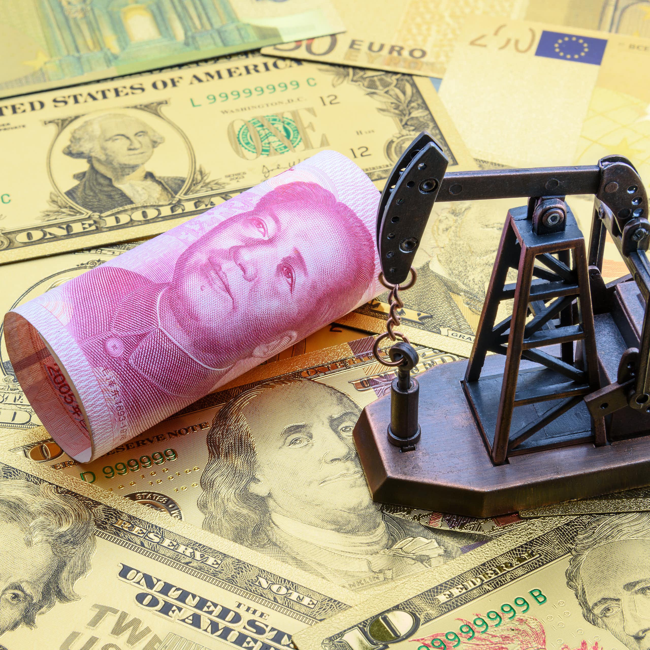 Chevalet de pompage de pétrole sur des billets de dollars, d'euros et de yuans.