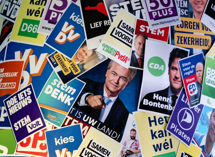 A board featuring lots of different Dutch political parties' campaign posters.