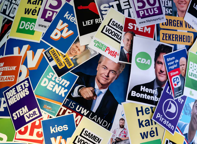 A board featuring lots of different Dutch political parties' campaign posters.