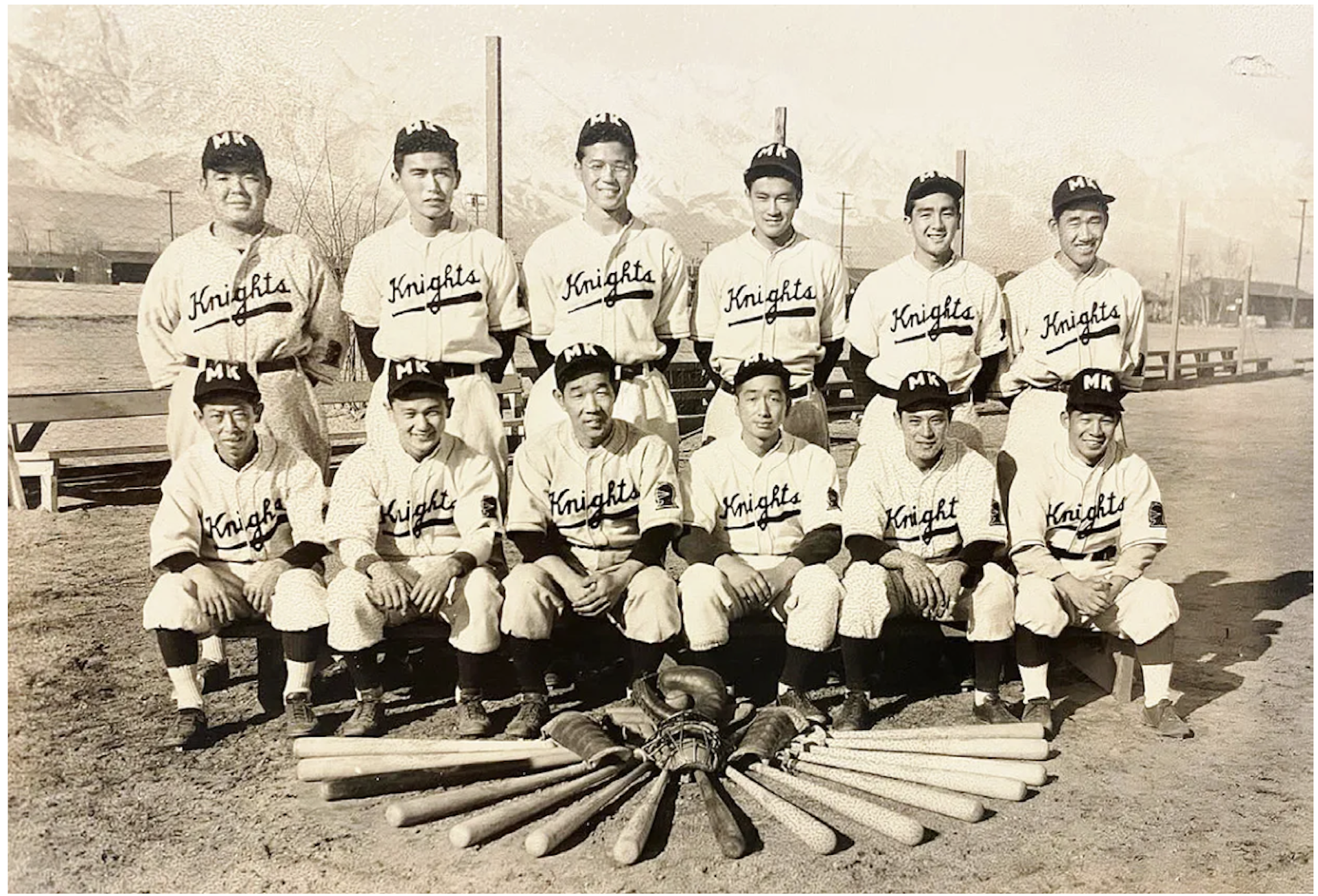Sepia toned photograph of Japanese Americans wearing baseball uniforms and posing for a team picture.