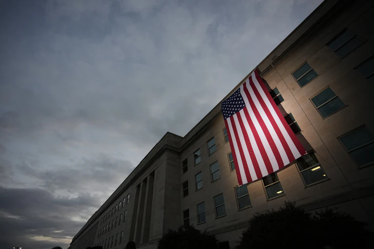 A U.S. flag is draped over a concrete building.