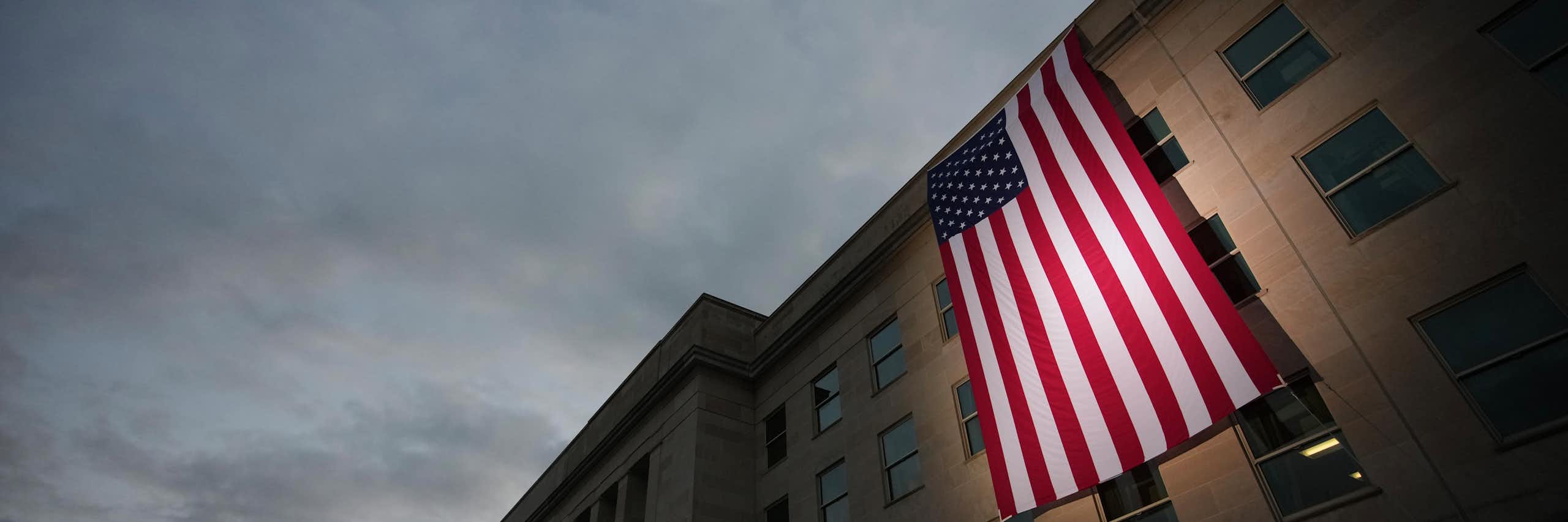 A U.S. flag is draped over a concrete building.