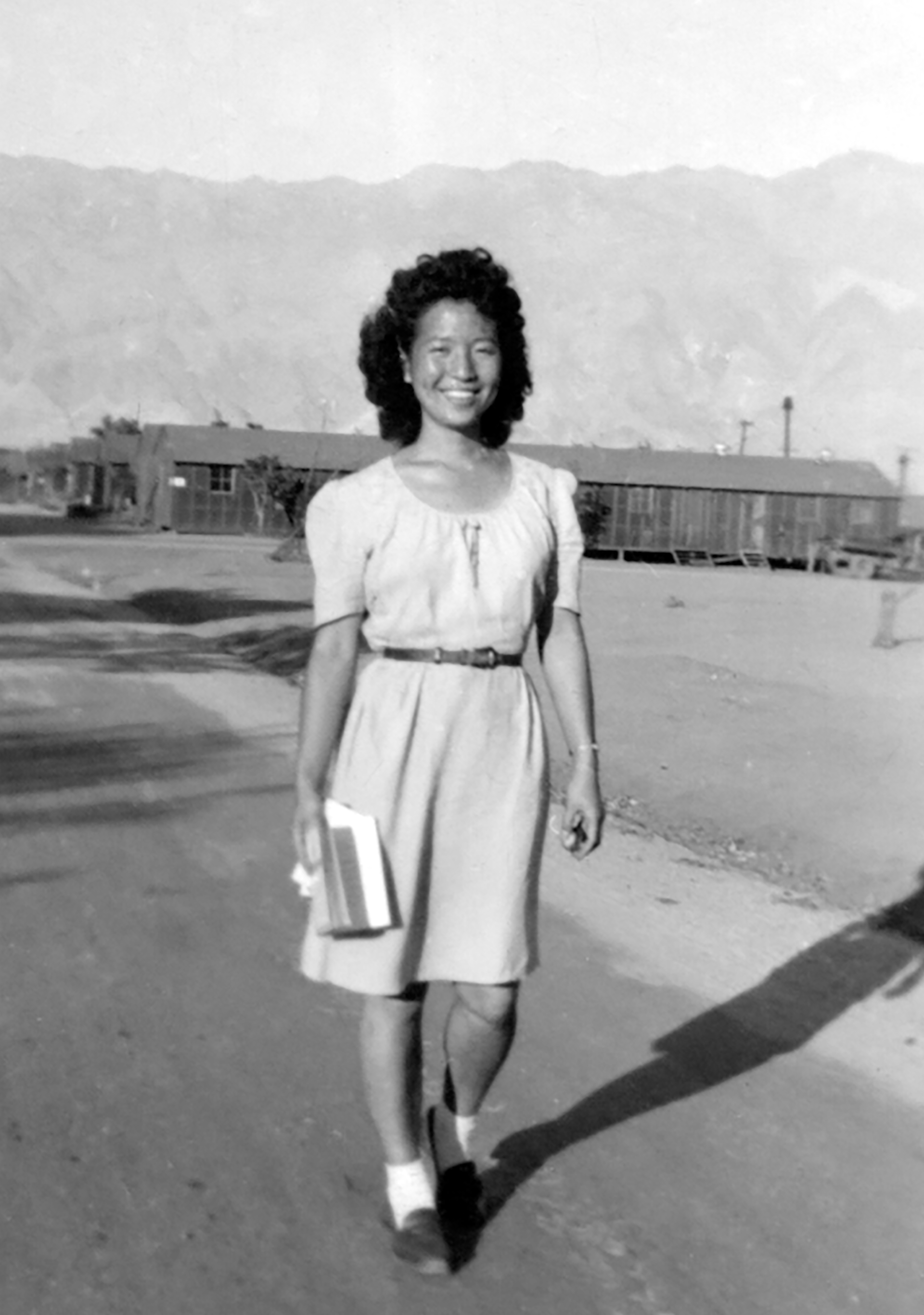 Black and white photo of Asian female teenager smiling and wearing a blouse.