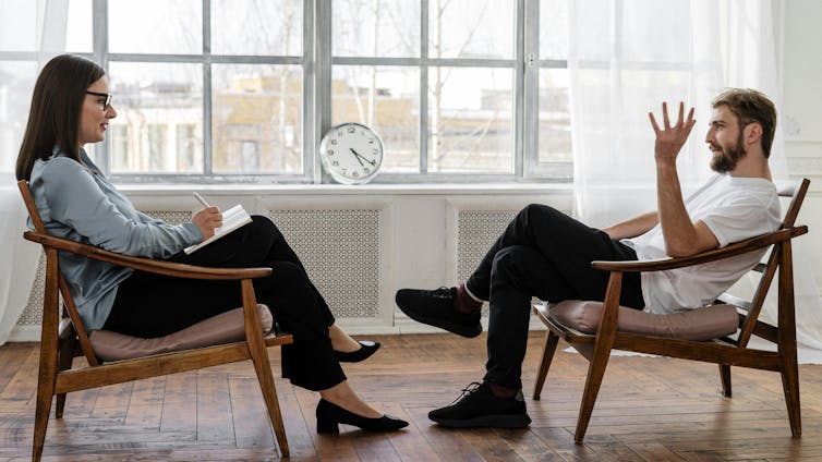 A therapist and her client talk in a well lit room.