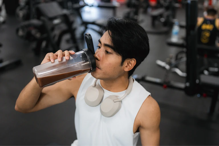 Man drinks protein shake at the gym