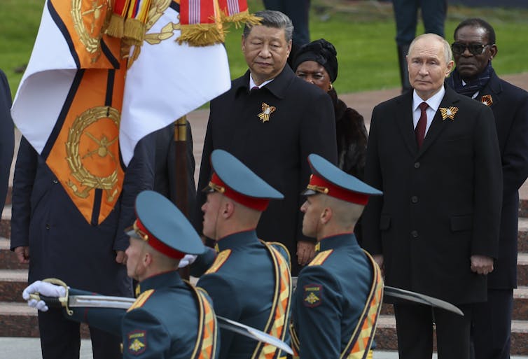 Vladimir Putin and Xi Jinping watch a military parade.