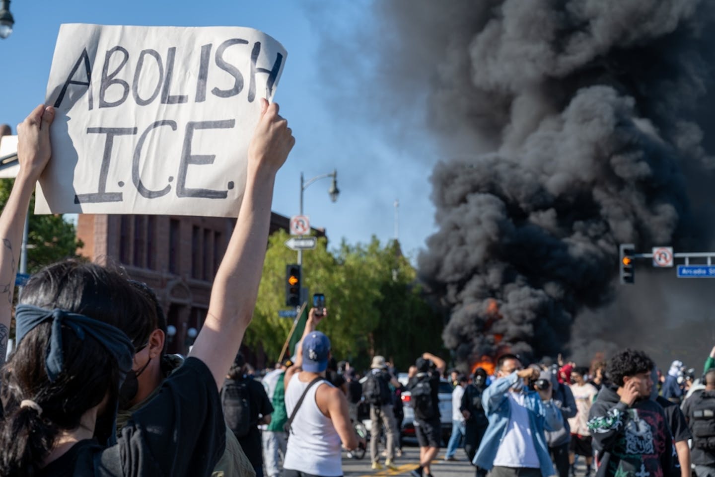 Una mujer sostiene una pancarta en alto que dice 'Abolish ICE'-