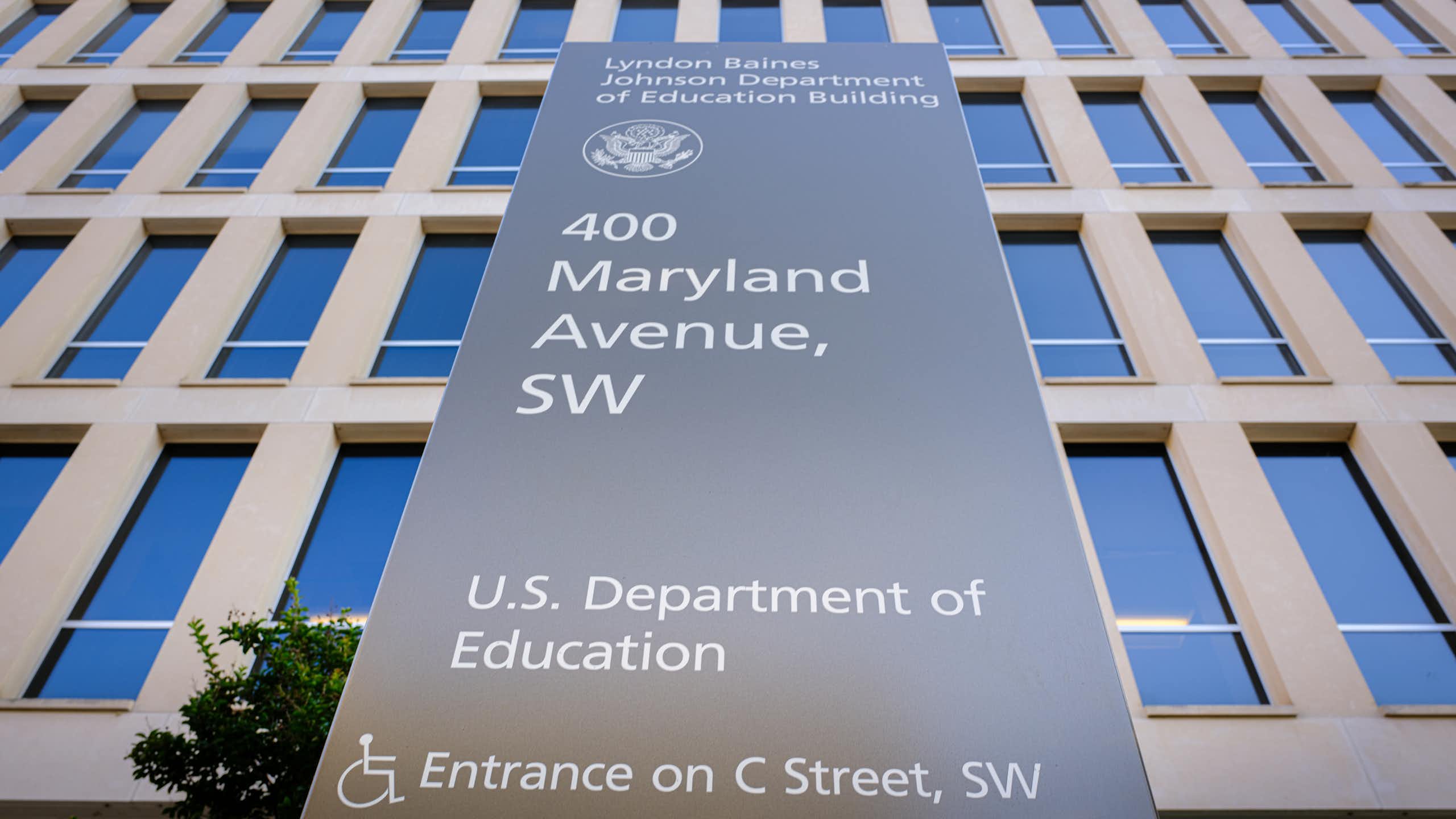 A large stone plaque says 400 Maryland Avenue, SW, U.S. Department of Education, in front of a large building with many windows.