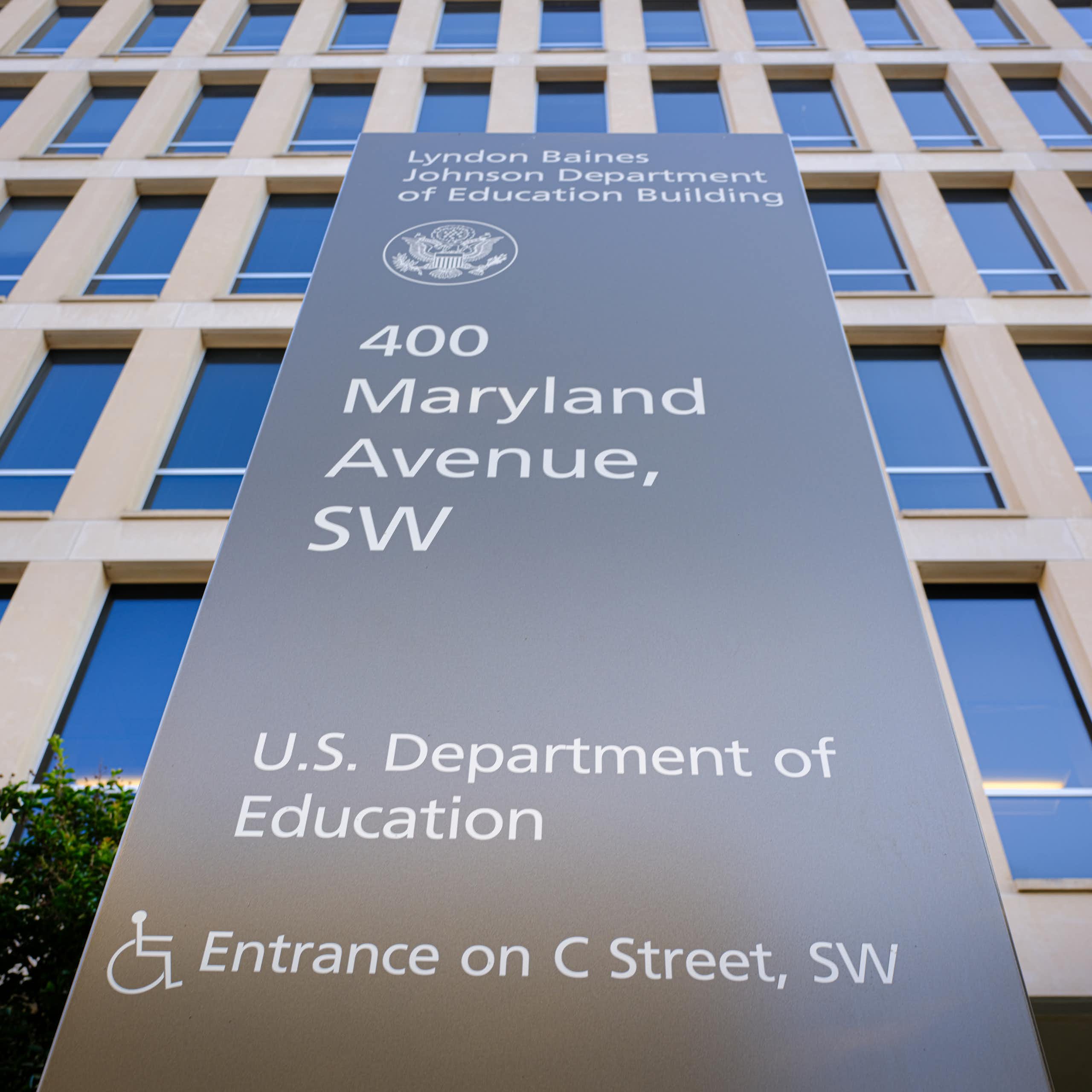 A large stone plaque says 400 Maryland Avenue, SW, U.S. Department of Education, in front of a large building with many windows.