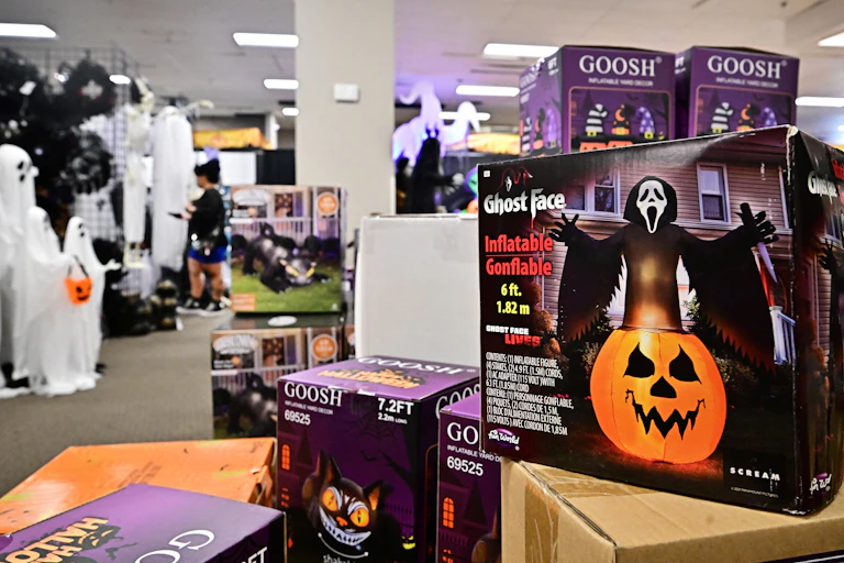 Boxes of ghost-themed Halloween lawn decorations are seen in a store.