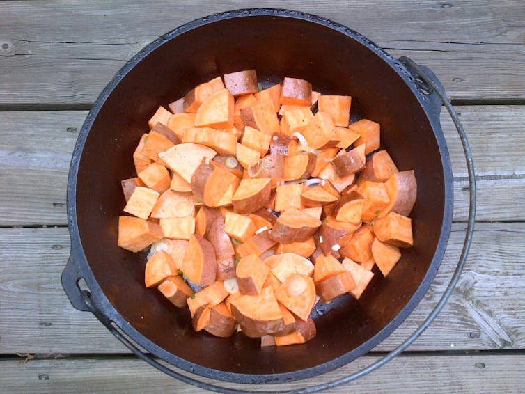 A cast iron pot of cubed sweet potatoes