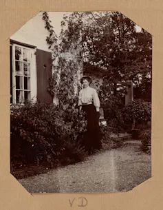 Violet Dickinson by a house.