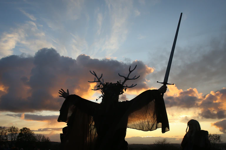 A man representing the Winter King holds a sword as he takes part in a sunset ceremony as they celebrate Samhain