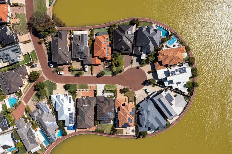 An aerial shot of a small peninsula of houses by a river