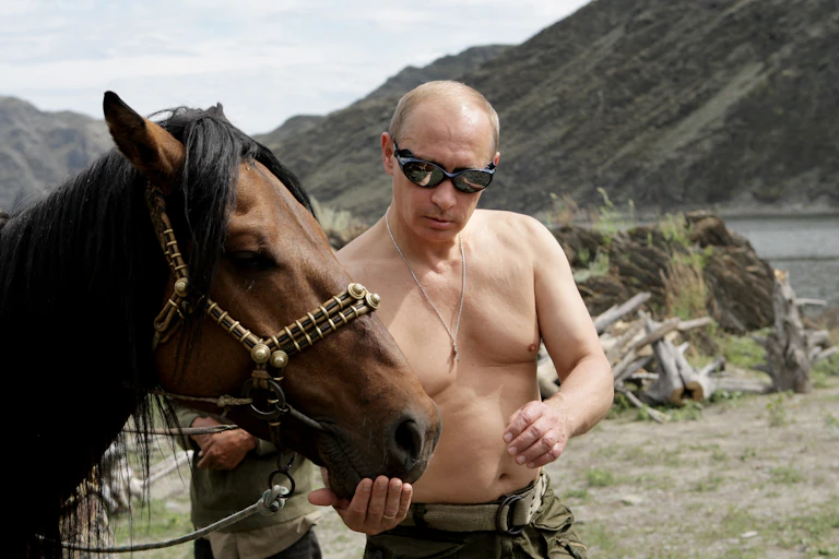 Poutine, torse nu, près d'un cheval.