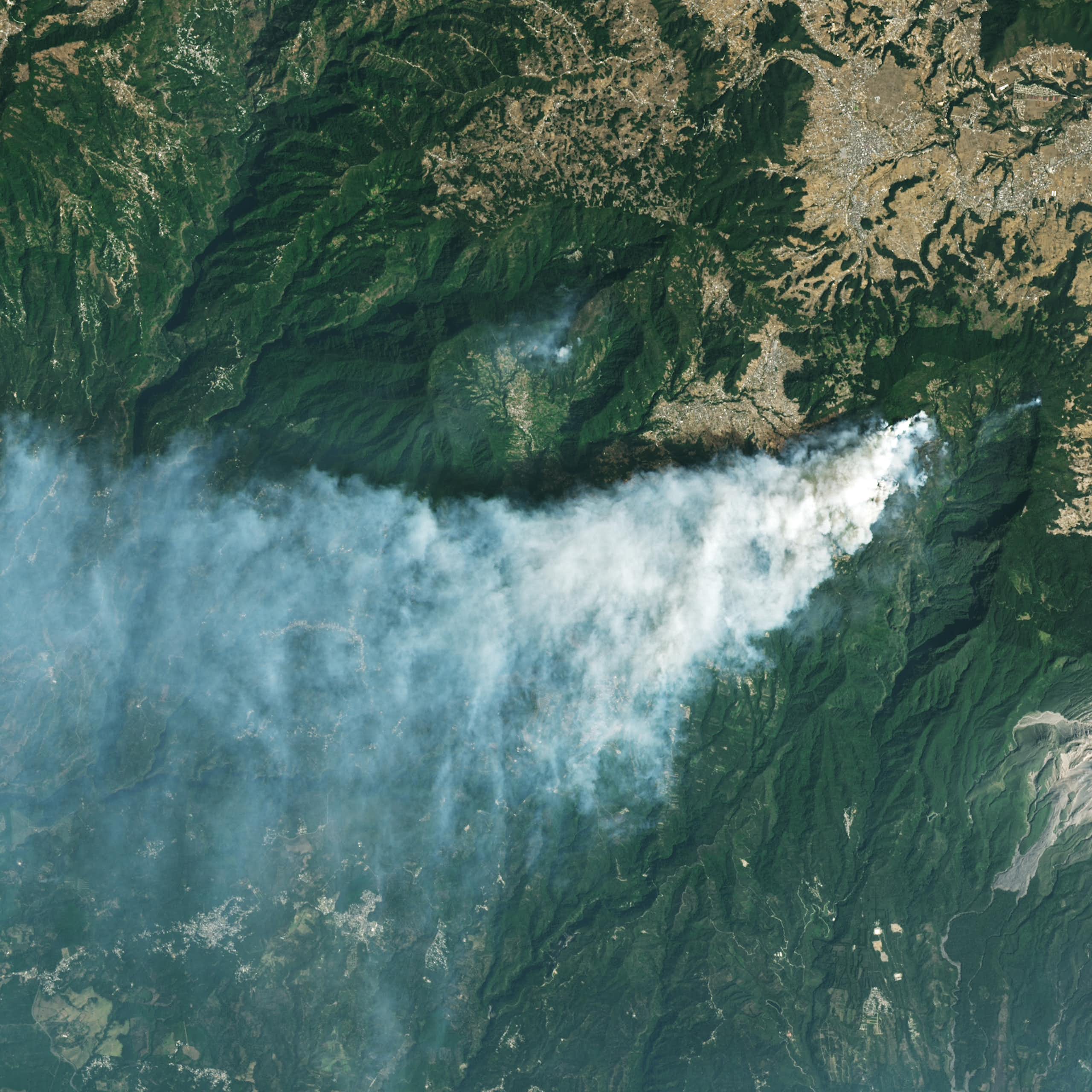 Humo de un incendio que se eleva de una zona montañosa en una imagen de satélite