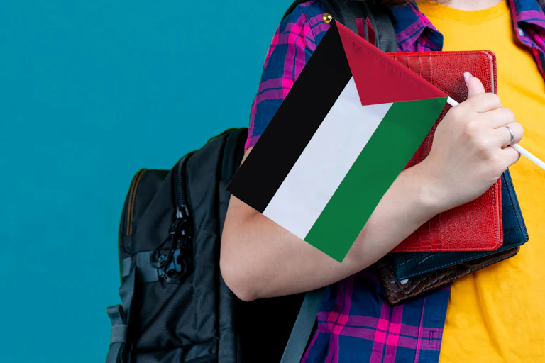 Una niña sostiene una bandera palestina.
