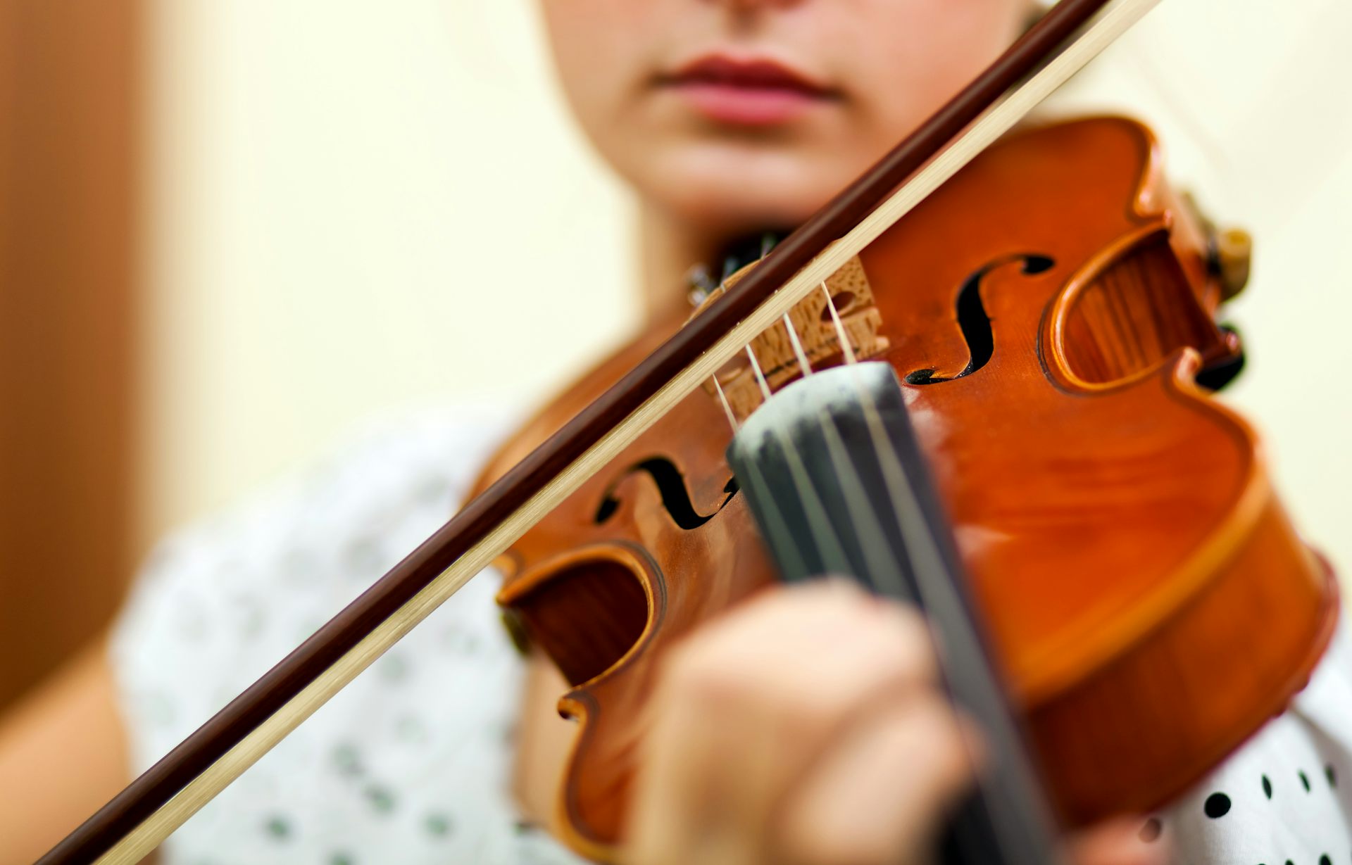 Plano de detalle de una mujer tocando el violín.