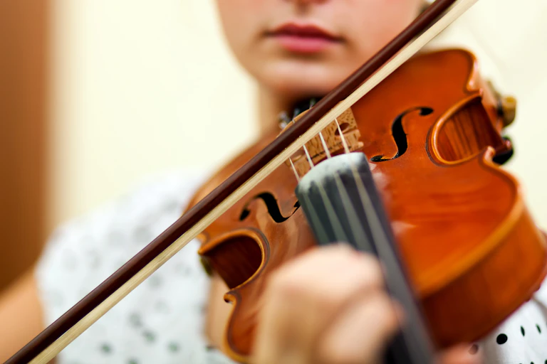 Plano de detalle de una mujer tocando el violín.