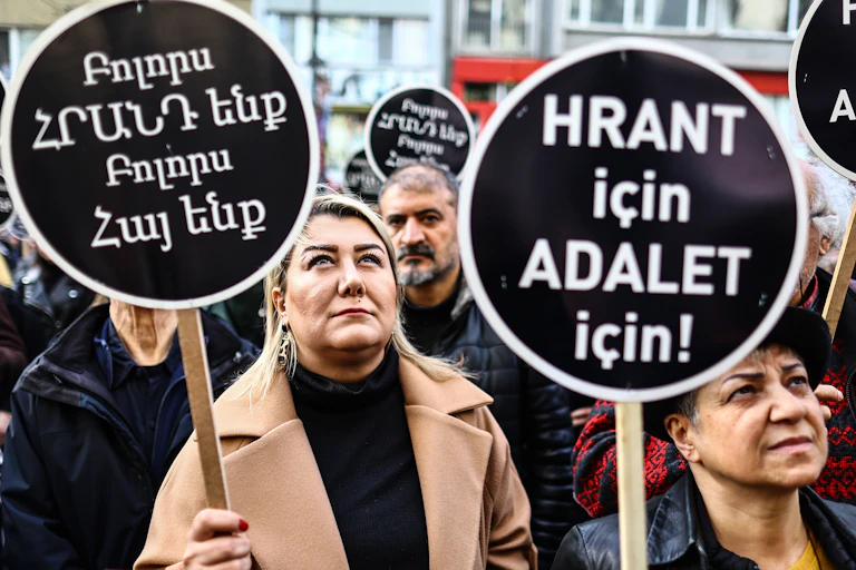 Turkish people hold banners reading 'We all are Hrant and Armenian' during a rally.