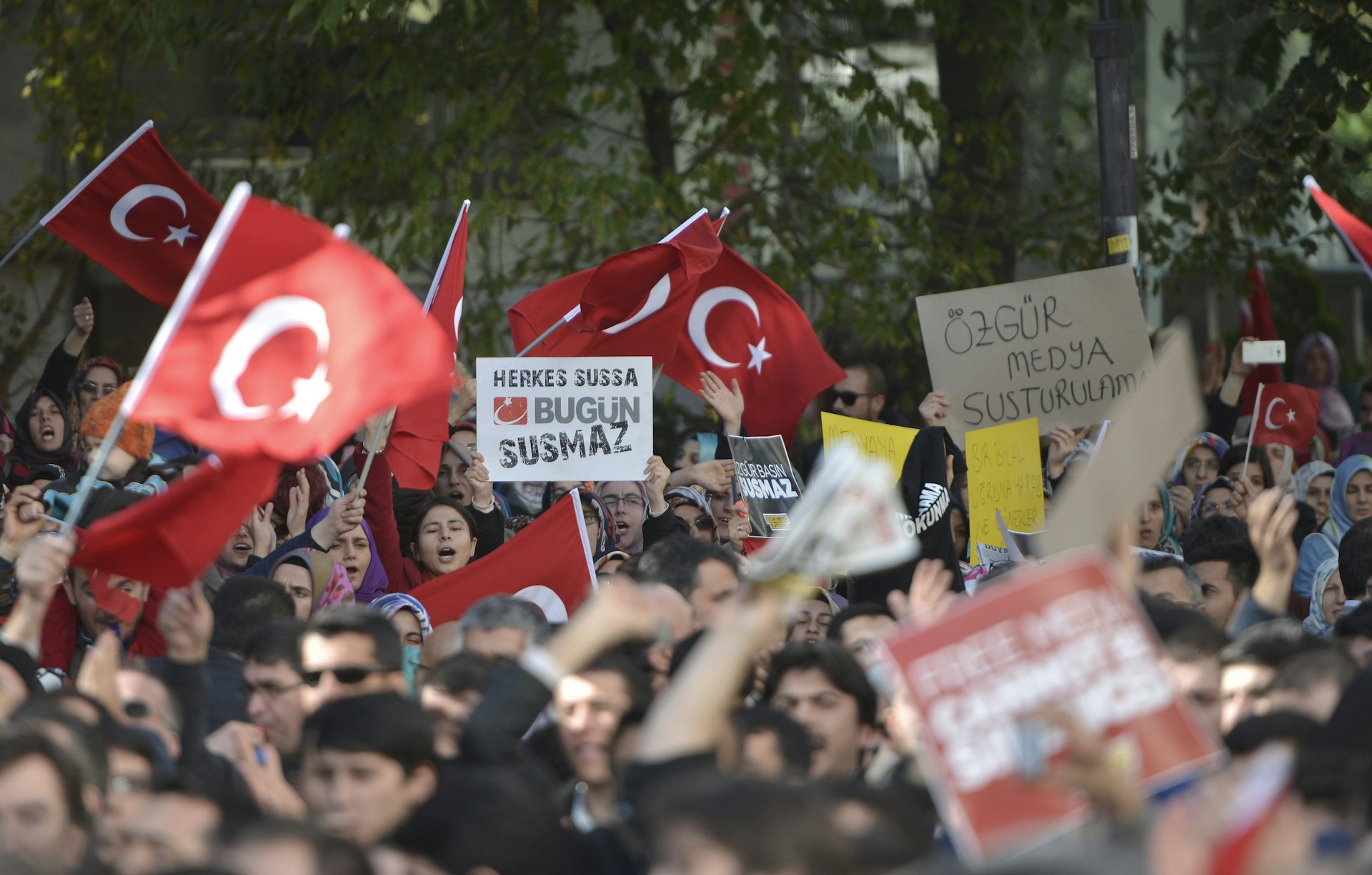 Protestors waving Turkish flags gather in front of the Kanaltürk TV building.