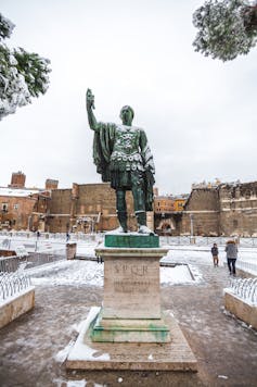 A statue of Nerva near the Colosseum under the snow.
