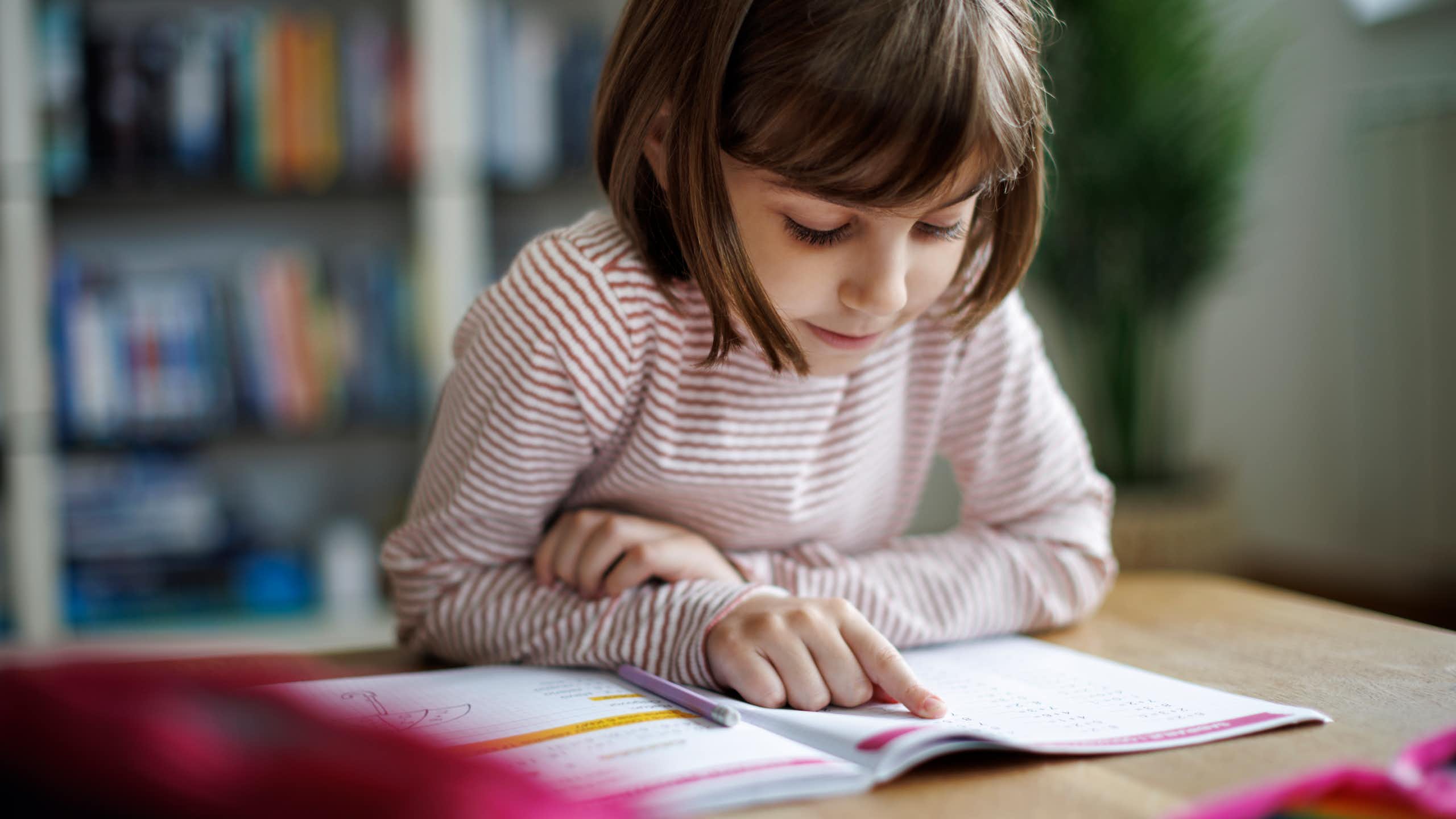 Young child reading a school work book