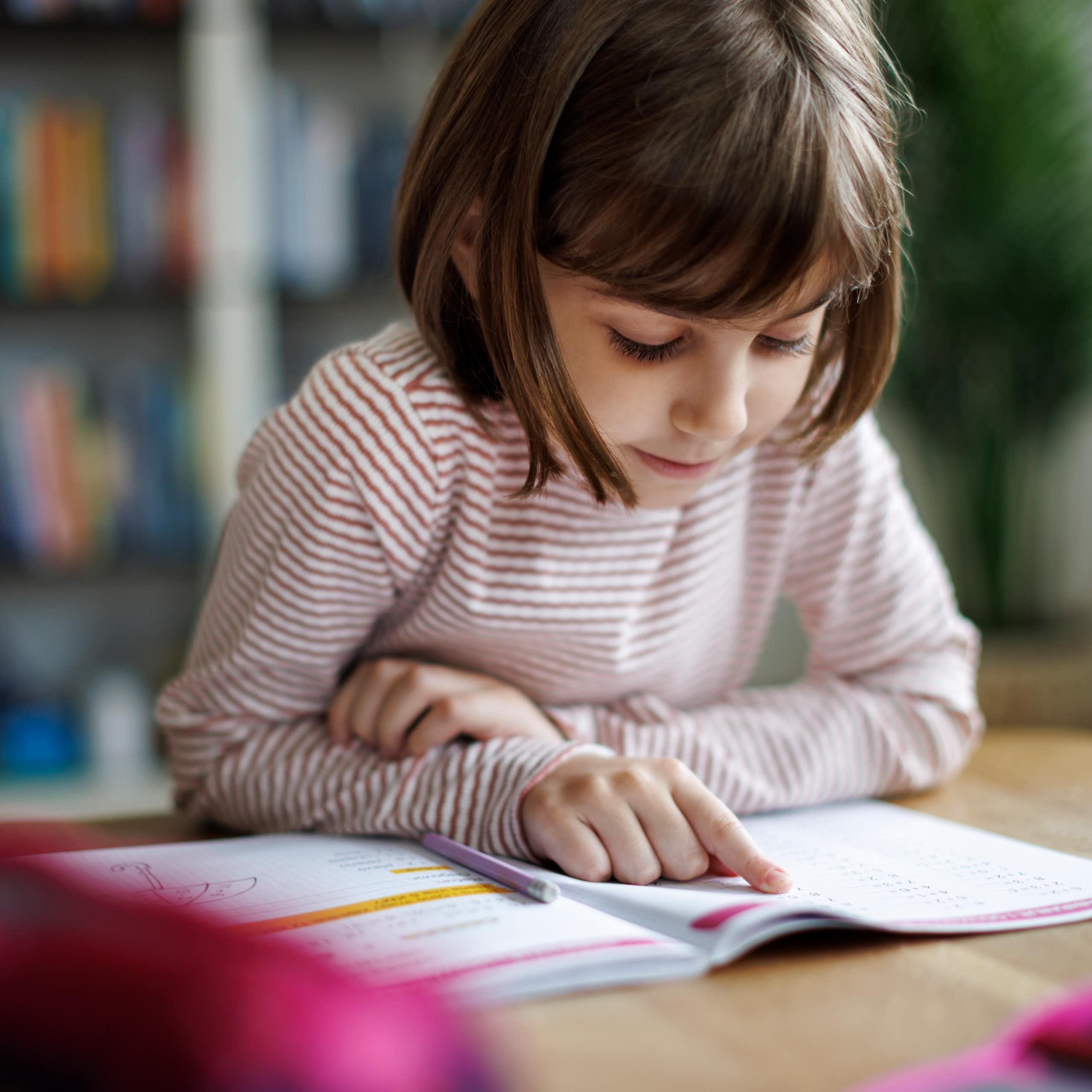 Young child reading a school work book