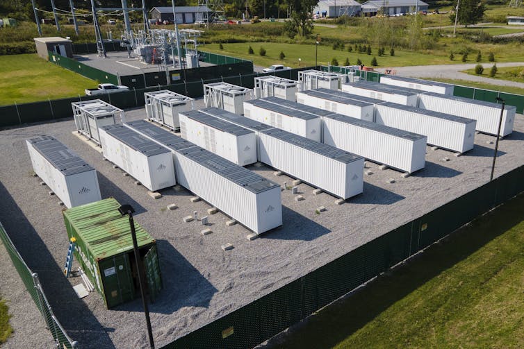 An aerial photo of about a dozen large, white, rectangular lithium batteries on a block.