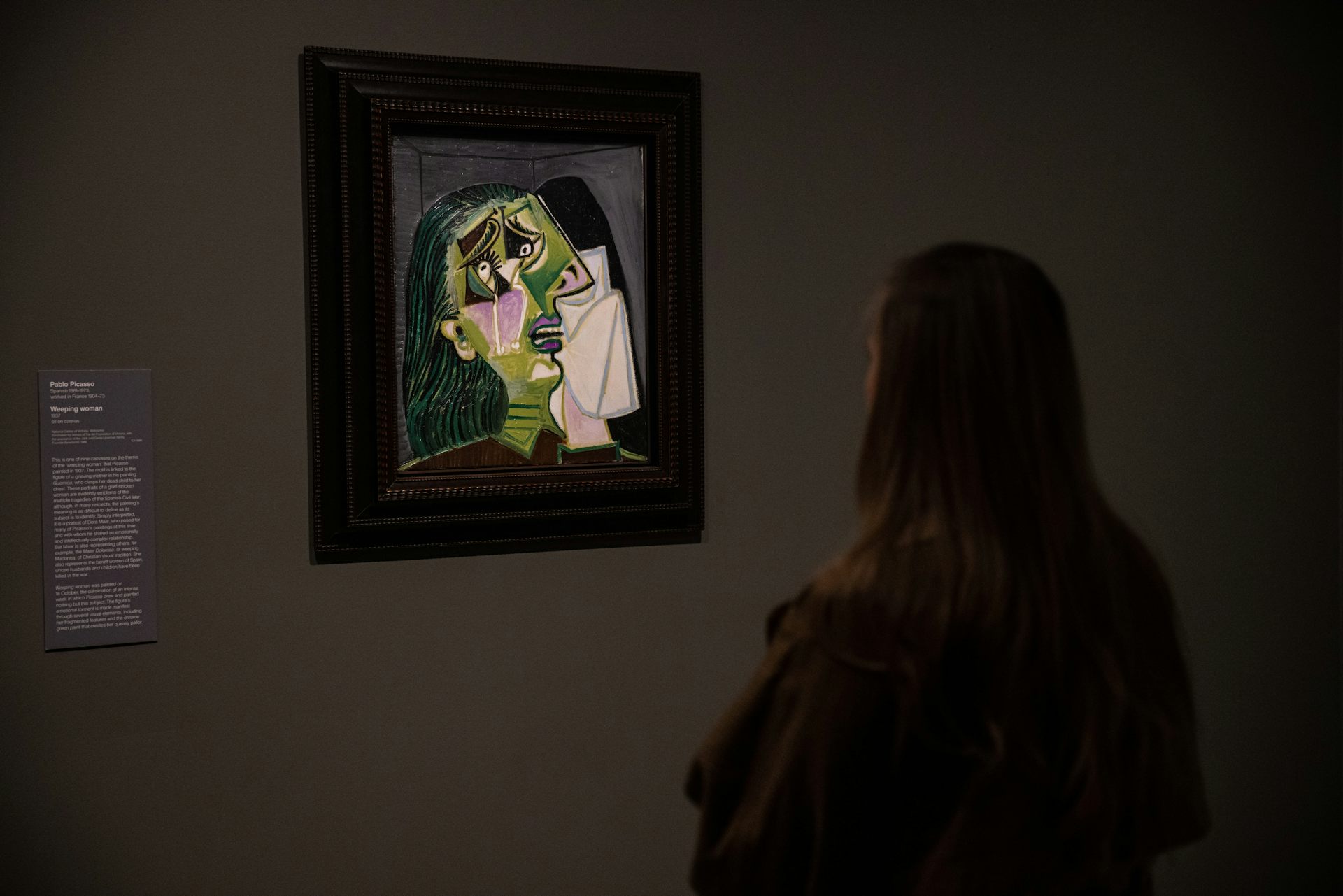 A woman stares at Weeping Woman.