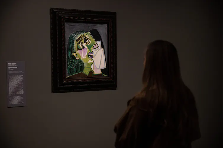 Uma mulher olha para a Mulher Chorando.