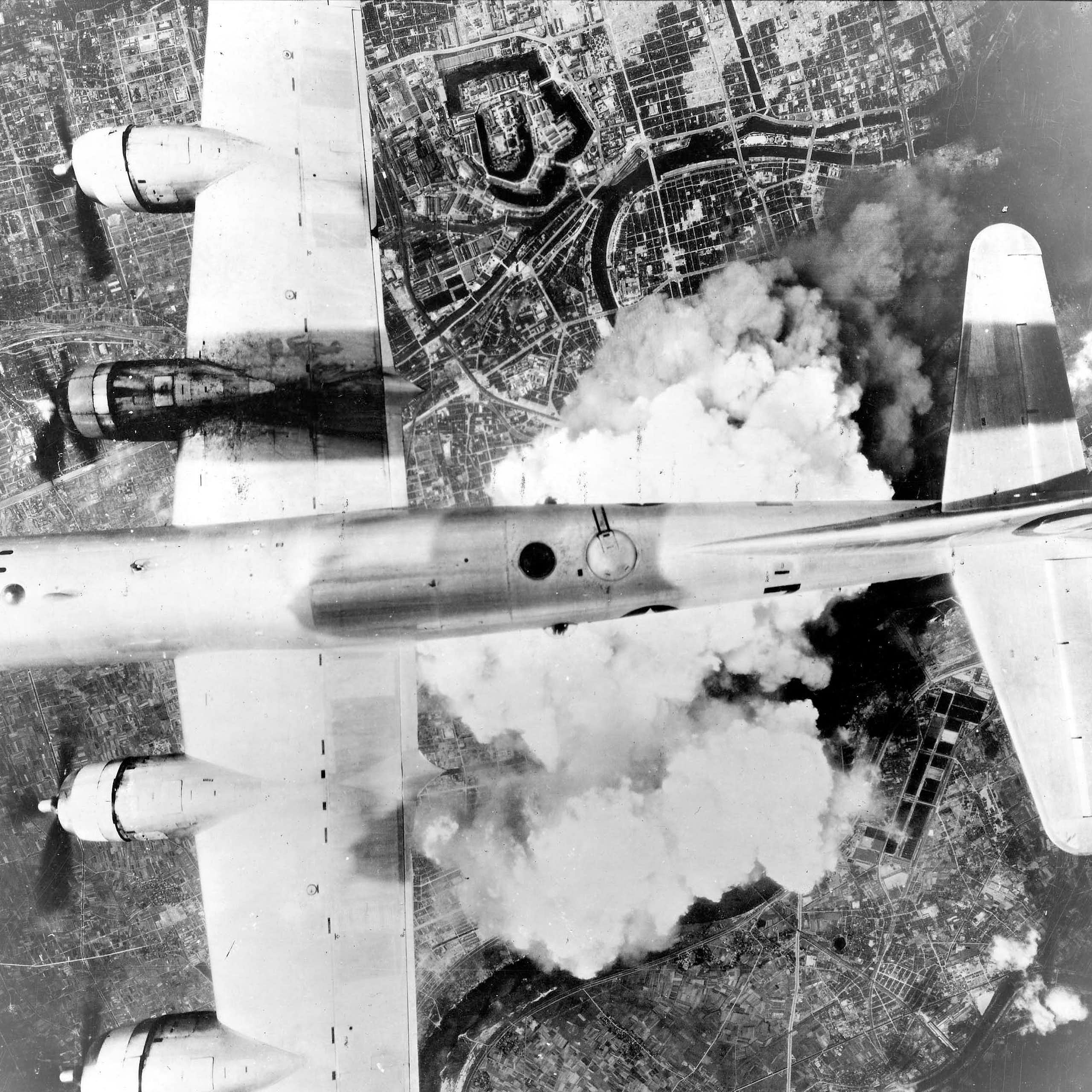 Black and white photo of a plane flying over clouds