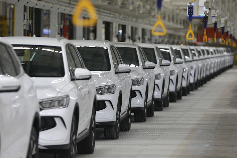 A line of brand new white cars.
