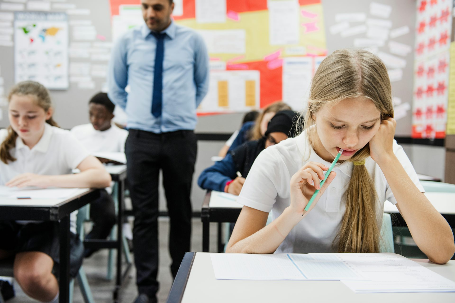 Teenagers in uniform sitting a classroom test