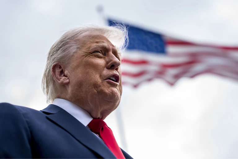 Donald Trump with US flag in background.