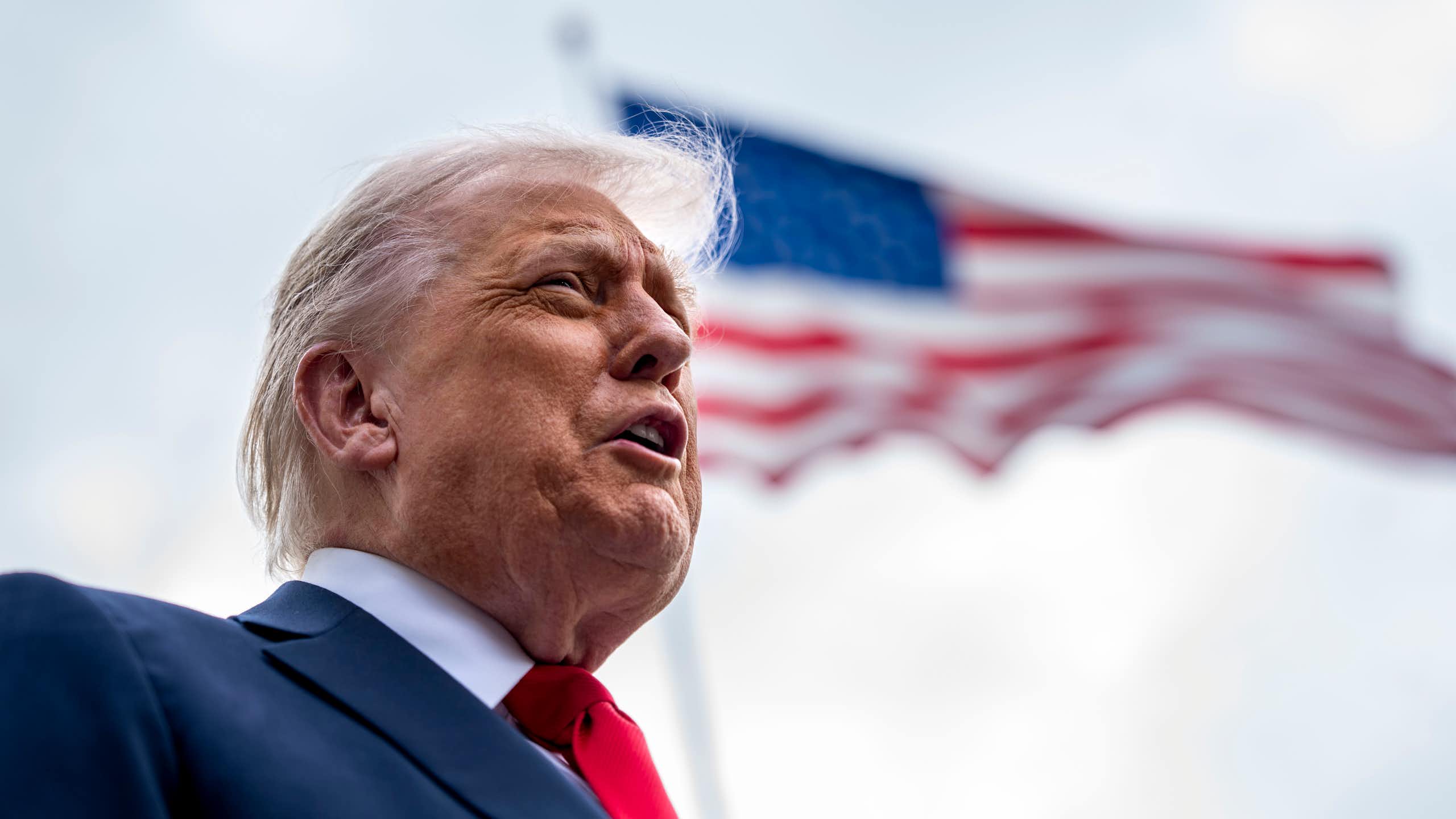 Donald Trump with US flag in background.