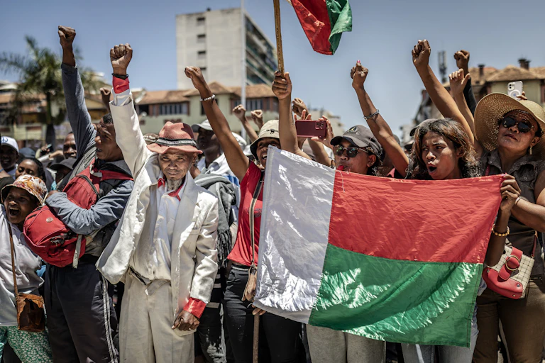 Residents and protesters hold Malagasy flags and chant slogans as they gather for a civil society rally demanding the resignation of President Andry Rajoelina in Antananarivo, on October 14, 2025.