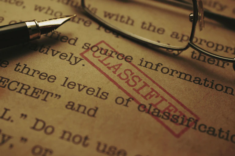 Stock photo of a document with a 'classified' stamp across the text