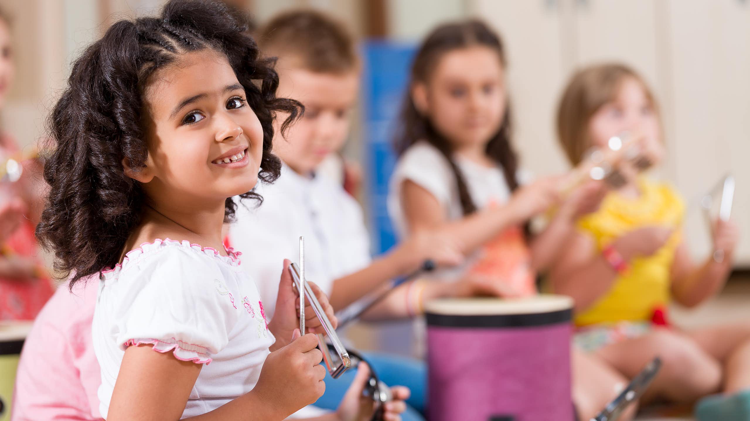 Niños tocando instrumentos de percusión en una clase.
