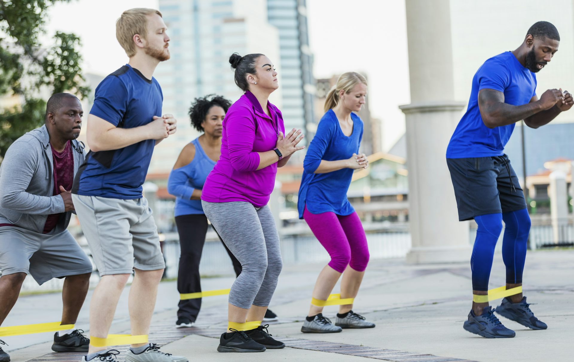 An instructor leads an outdoor exercise class.