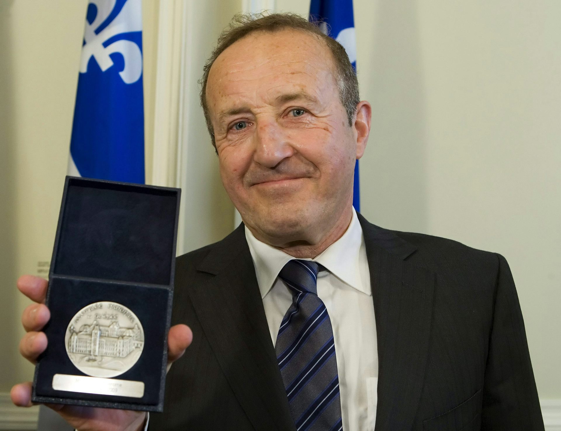 Le présentateur de télévision Bernard Derome tient sa Médaille d'honneur