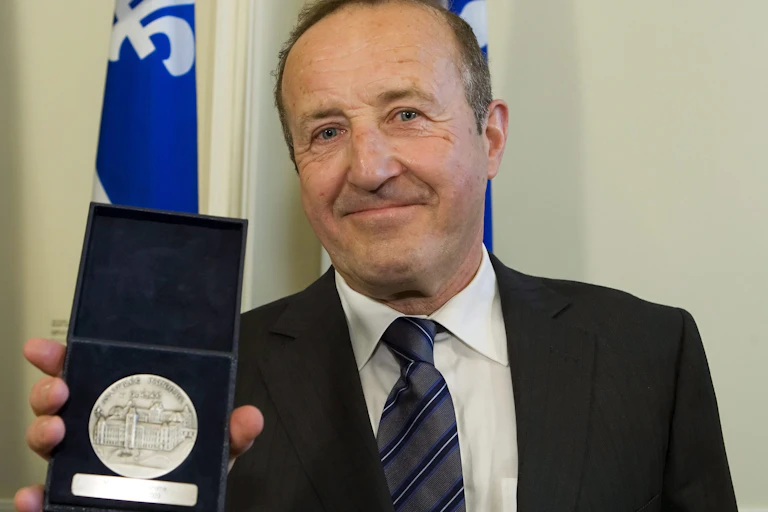 Le présentateur de télévision Bernard Derome tient sa Médaille d'honneur