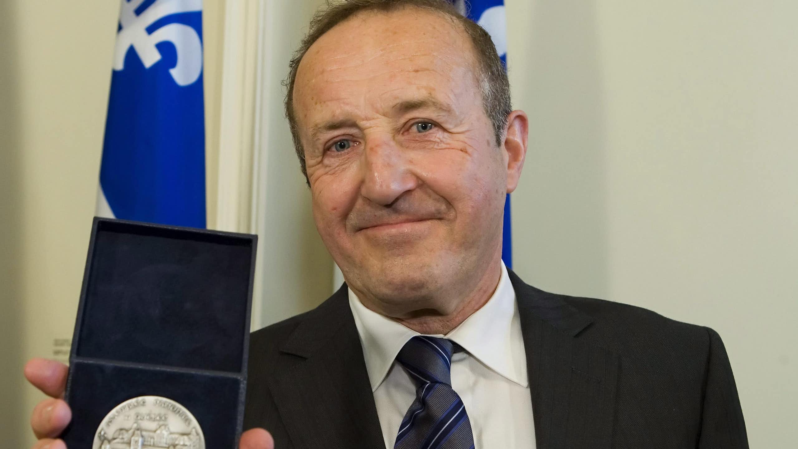 Le présentateur de télévision Bernard Derome tient sa Médaille d'honneur