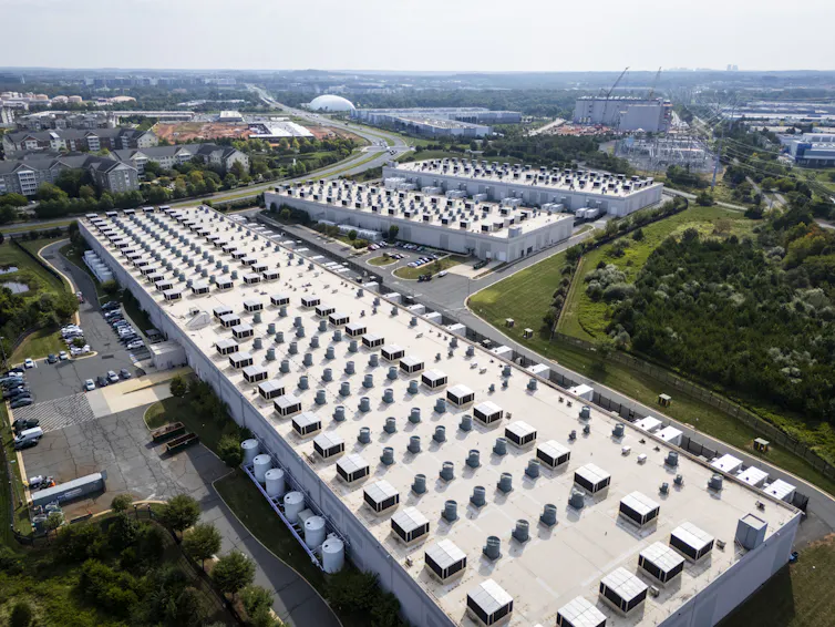 An aerial view of three large white buildings.