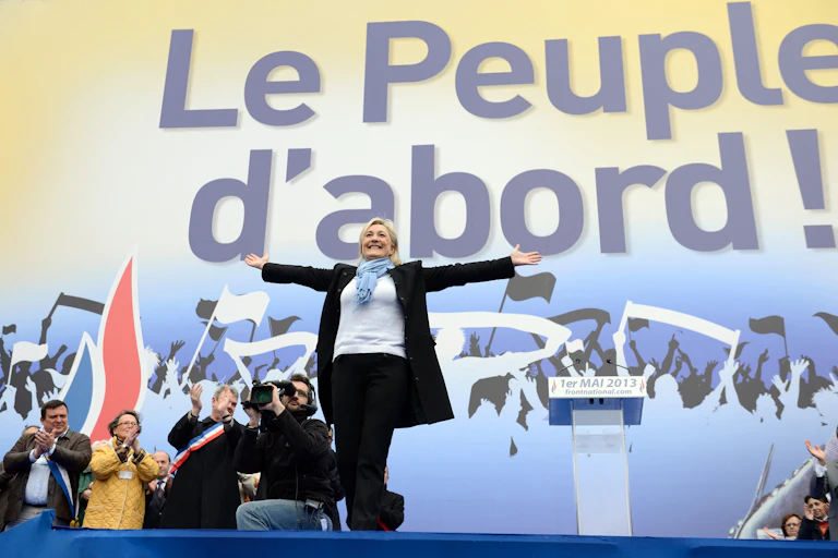 Marine Le PN, dans la position de Jesus devant une enseigne Le Peuple d'abord