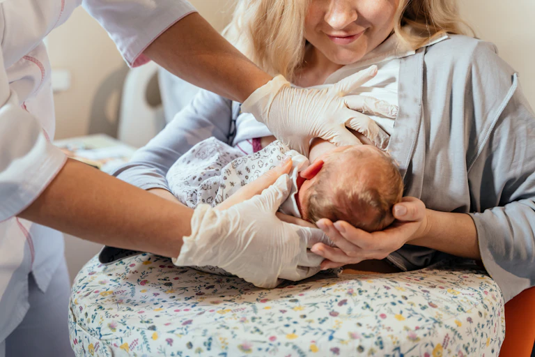 Une soignante apprend à une jeune mère à allaiter son enfant.