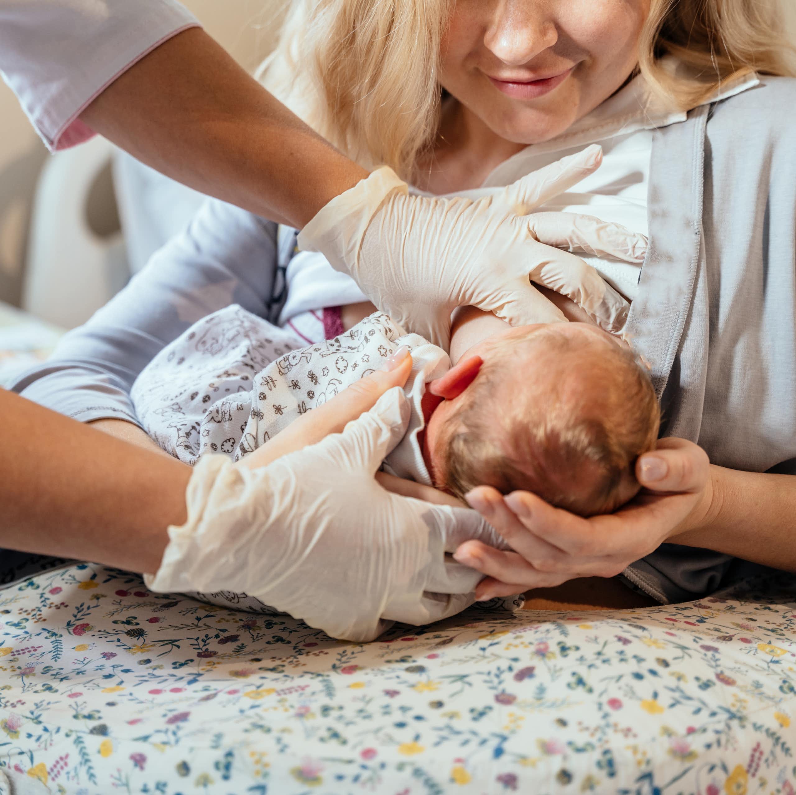 Une soignante apprend à une jeune mère à allaiter son enfant.
