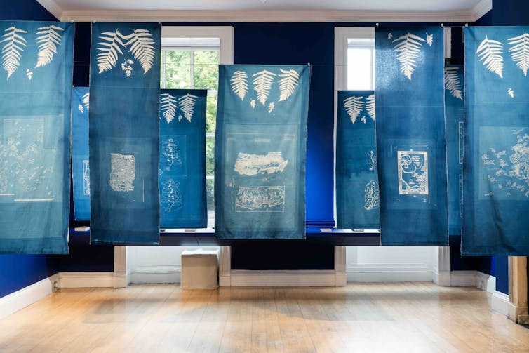 An exhibtion of maps printed on blue cloth.