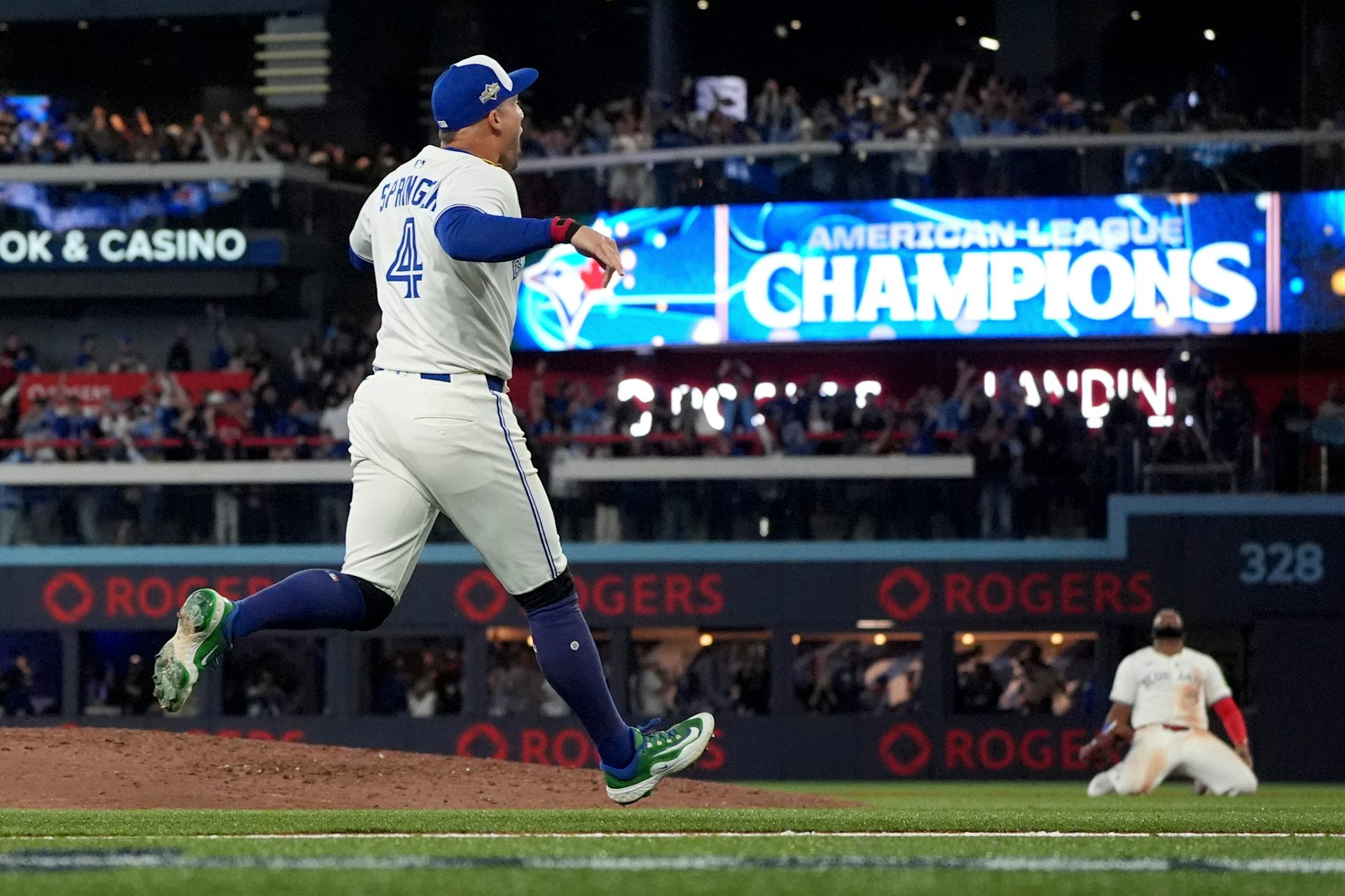 Two baseball players celebrate. One is on his knees.